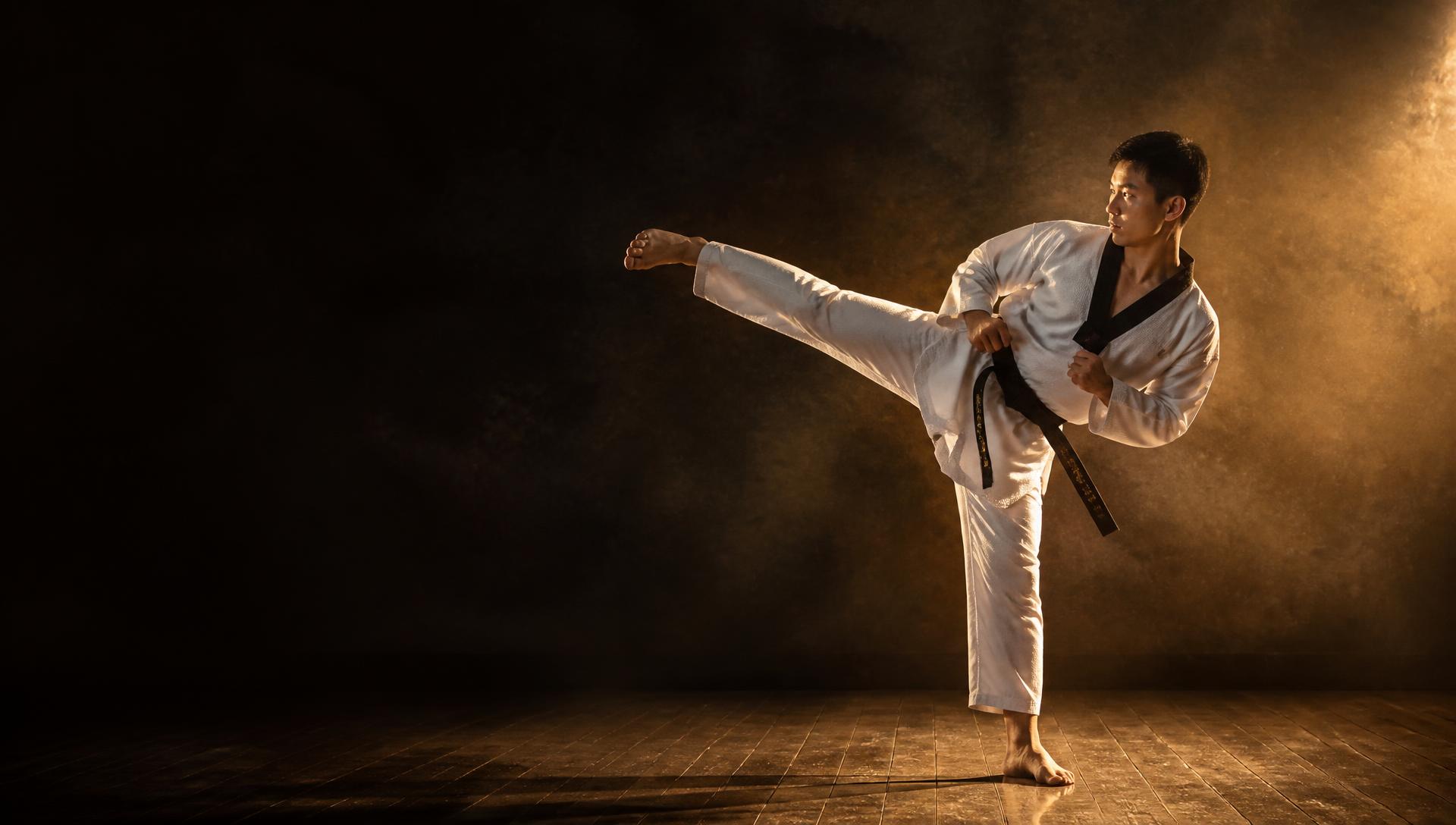 Taekwondo black belt performing a side kick in a London dojang